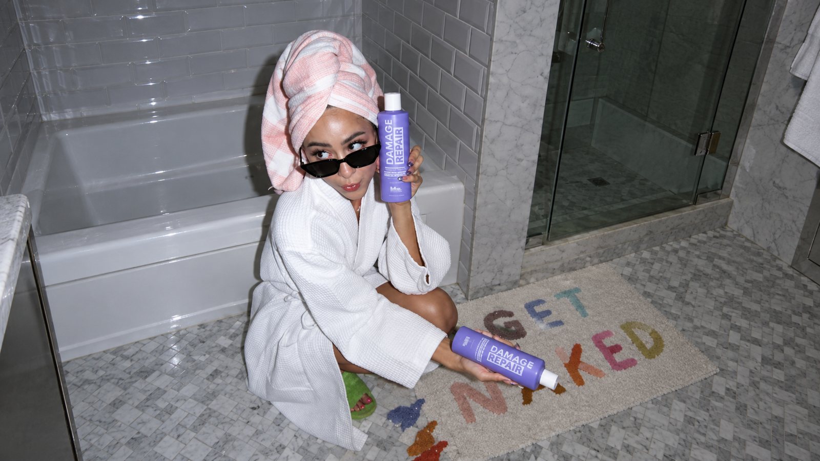 Woman posing with BHS Haircare Damage Repair bottles