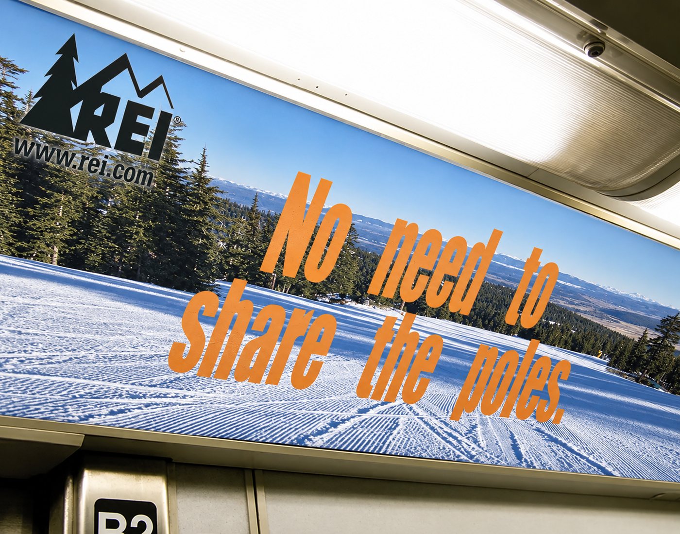 REI car card over a ski slope: No need to share the poles.
