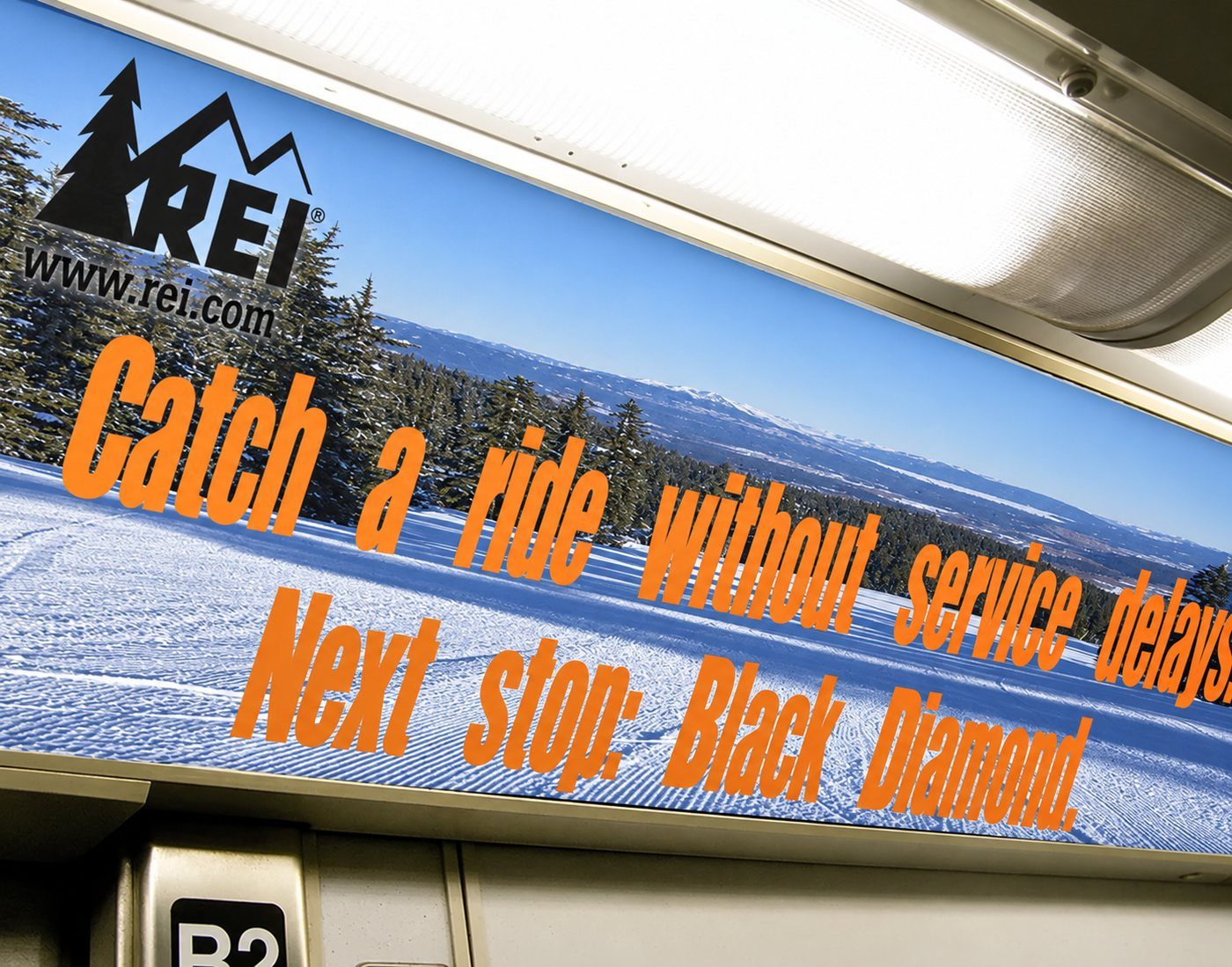 REI car card over a ski slope: Catch a ride without service delays. Next stop: Black Diamond.