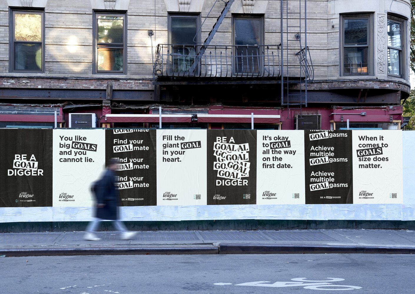 Street wall of Be a Goal Digger posters in New York, with a pedestrian walking past