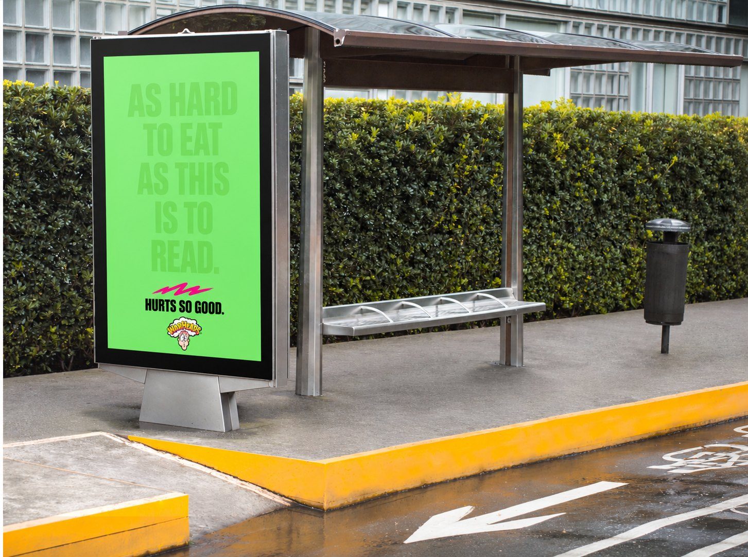 Warheads bus shelter ad with faint green-on-green type: As hard to eat as this is to read. Hurts so good.