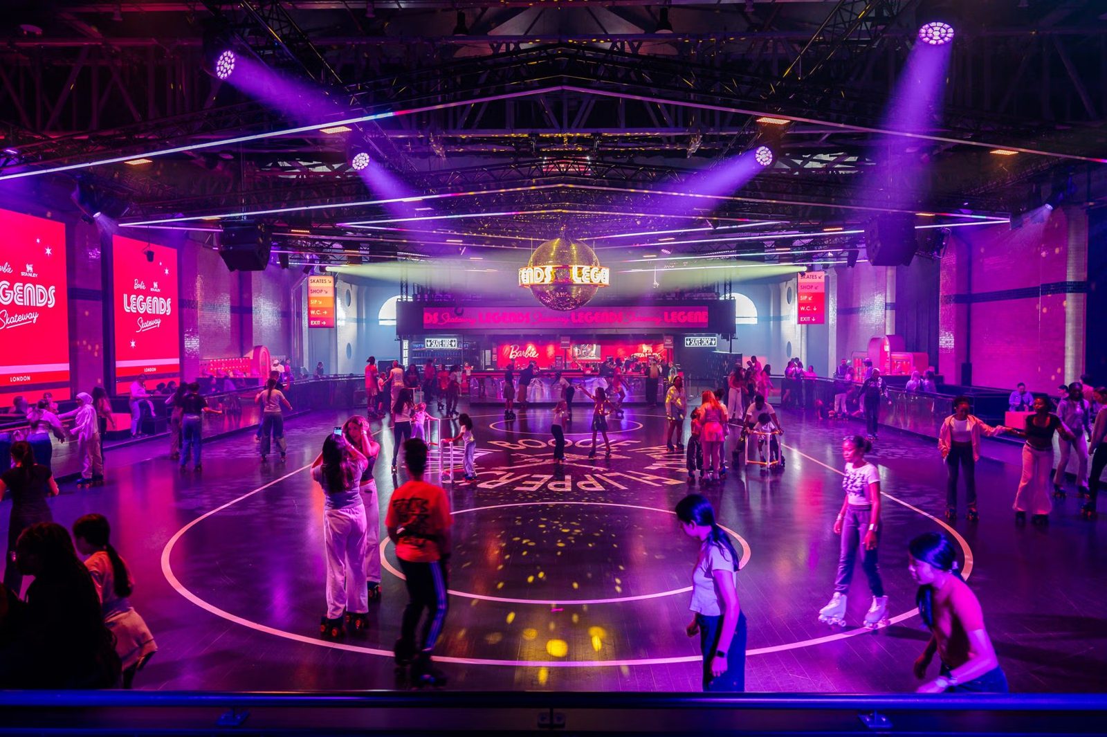 Wide view of the Legends roller rink lit in pink and purple