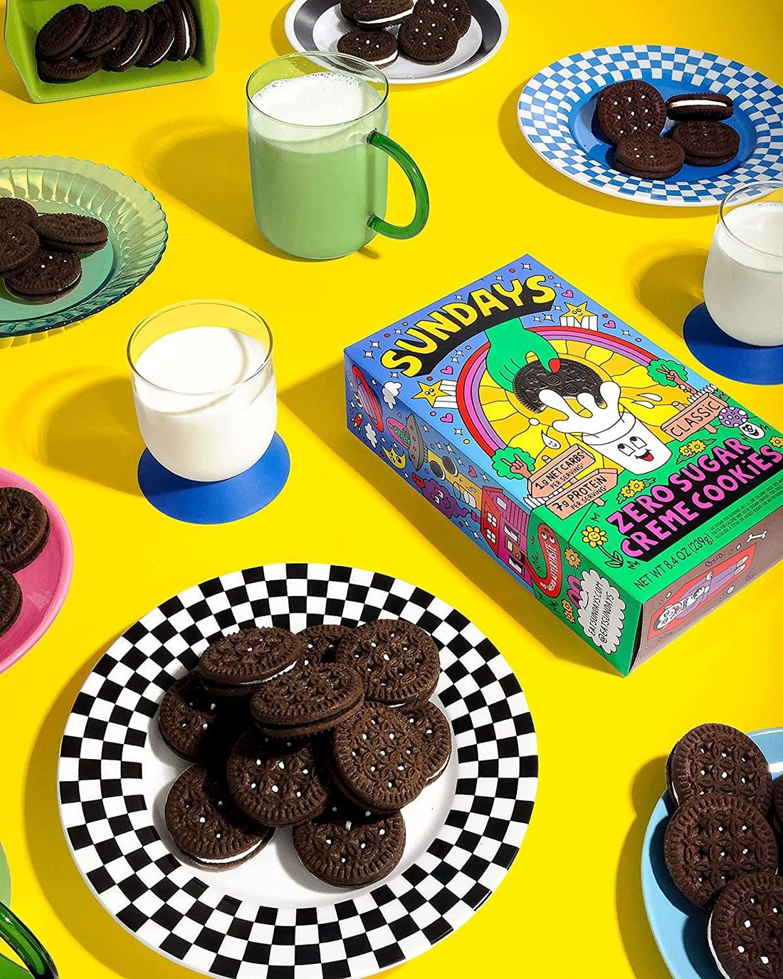 Sundays box on a bright yellow table surrounded by plates of cookies and glasses of milk
