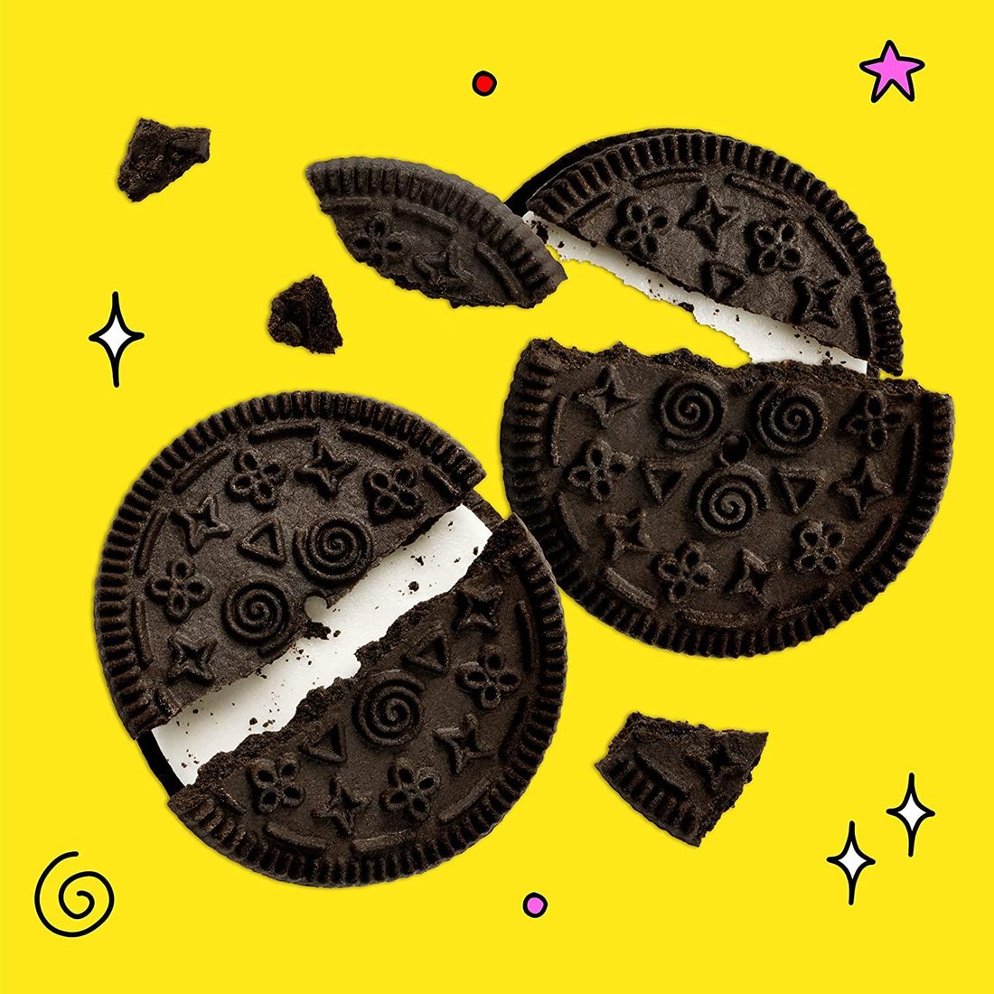 Two Sundays cookies cracked open on yellow, showing swirl and flower patterns and creme filling